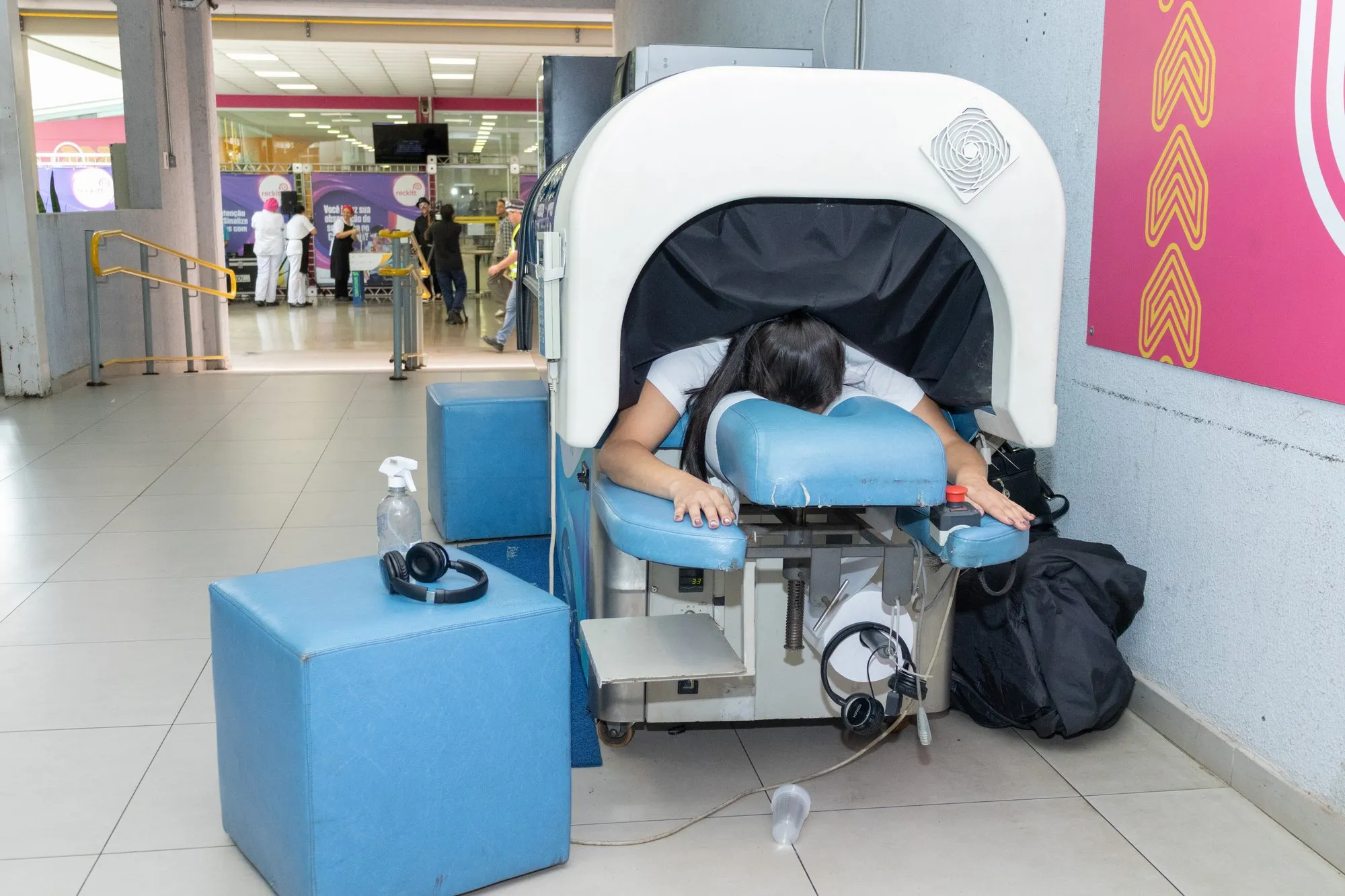 Visitantes em volta da Aquamassagem no corredor de um evento